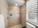 Shower featuring tan tiles, with a window and shower head at 13216 Legends Trl, Dade City, FL 33525