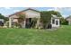 Backyard view with covered patio and lush landscaping at 329 Grayston Pl # 112, Sun City Center, FL 33573