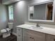 The bathroom features a stylish vanity with light countertop and sink, paired with a framed mirror at 1920 N Highland Ave, Clearwater, FL 33755