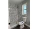 This remodeled bathroom features marble tiled shower and a window for great light and ventilation at 1920 N Highland Ave, Clearwater, FL 33755