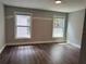 Bright bedroom features dark floors and two windows that provide natural light and exterior views at 1920 N Highland Ave, Clearwater, FL 33755