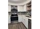 Modern kitchen featuring stainless steel appliances, white cabinets, and decorative tile backsplash at 1920 N Highland Ave, Clearwater, FL 33755