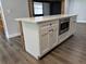 Kitchen island featuring white cabinets, quartz countertop, and a built-in microwave at 1920 N Highland Ave, Clearwater, FL 33755