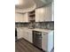Updated kitchen featuring white cabinets, modern hardware, stainless steel appliances, and a tile backsplash at 1920 N Highland Ave, Clearwater, FL 33755