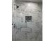 Close up view of the shower's stylish marble tile walls and decorative niche at 1920 N Highland Ave, Clearwater, FL 33755