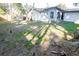 Sunny backyard with sparse grass and tree shadows at 1920 N Highland Ave, Clearwater, FL 33755