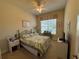 Cozy bedroom with leafy bedding, carpet flooring, a ceiling fan, and a large window with blind coverings at 15953 Cobble Mill Dr, Wimauma, FL 33598