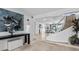 Spacious foyer with modern artwork, a staircase with glass railings, and bright, open transitions at 780 Eldorado Ave, Clearwater, FL 33767