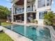 Outdoor swimming pool with patio, lounge chairs, a manicured lawn, and a view of the home's balconies at 780 Eldorado Ave, Clearwater, FL 33767