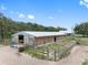 Exterior view of a large barn with fenced area at 8602 State Road 674, Wimauma, FL 33598