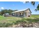 Backyard view of a ranch-style home with an above ground pool and a covered porch at 8602 State Road 674, Wimauma, FL 33598