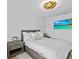 Spacious bedroom with queen bed, wood floors, and large TV at 780 Eldorado Ave, Clearwater, FL 33767