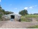 Barn with wooden siding, metal roof, and multiple stalls at 8602 State Road 674, Wimauma, FL 33598