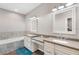 Elegant bathroom with double vanity, soaking tub, and large mirrors at 8602 State Road 674, Wimauma, FL 33598