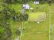 An aerial view of a property with multiple structures, a large pond, and a smaller pond, set against a backdrop of trees at 3520 Leslie West Rd, Dover, FL 33527