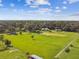 Aerial view of a sprawling property featuring a pond, several buildings, and lush green fields under a blue, partly cloudy sky at 3520 Leslie West Rd, Dover, FL 33527