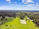 Expansive aerial shot of the property highlighting a pond, green fields, and surrounding wooded areas with lots of privacy at 3520 Leslie West Rd, Dover, FL 33527