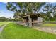 Exterior view of a rustic barn with fenced enclosure, located along a gravel road at 3520 Leslie West Rd, Dover, FL 33527