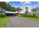 Charming home featuring a metal roof, spacious carport, brick chimney, and lush landscaping, showcasing curb appeal at 3520 Leslie West Rd, Dover, FL 33527