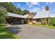 Charming home featuring a metal roof, spacious carport, brick chimney, and lush landscaping, showcasing curb appeal at 3520 Leslie West Rd, Dover, FL 33527