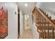 Hallway with staircase and bathroom, neutral color palette, and tile flooring throughout at 3520 Leslie West Rd, Dover, FL 33527
