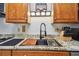 Kitchen featuring a stainless steel sink, granite countertops, and modern faucet with built-in cutting board at 3520 Leslie West Rd, Dover, FL 33527
