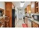 Galley kitchen with stainless steel appliances, granite countertops, and wood cabinets providing ample storage at 3520 Leslie West Rd, Dover, FL 33527
