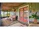 Cozy lanai featuring a rattan sofa, glass table, ceiling fans, and red french doors at 3520 Leslie West Rd, Dover, FL 33527