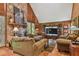 Cozy living room featuring wood paneled walls, stone fireplace, and comfortable seating, perfect for relaxation at 3520 Leslie West Rd, Dover, FL 33527