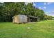 Metal outbuilding with an open carport attached, offering storage and workspace with green lawns surrounding at 3520 Leslie West Rd, Dover, FL 33527