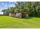 Spacious outbuilding with carport covered by a tarp, perfect for storage and outdoor projects on grassy land at 3520 Leslie West Rd, Dover, FL 33527