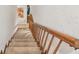 Carpeted stairs with wooden banisters lead to the lower level of the home at 3520 Leslie West Rd, Dover, FL 33527