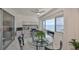 Small dining area with glass table and chairs, built in desk and water views at 100 Bluff View Dr # 404A, Belleair Bluffs, FL 33770
