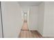 Long hallway with light wood-look flooring and stairs at 8738 N Tangerine Pl, Tampa, FL 33617