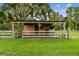 Simple wooden barn with a shaded area and fence at 3520 Leslie West Rd, Dover, FL 33527