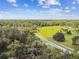 Aerial view showcasing a large property with green pastures and a home nestled among the trees at 3520 Leslie West Rd, Dover, FL 33527
