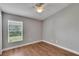 Bedroom with wood-look flooring and window with blinds at 907 Seminole Sky Dr, Ruskin, FL 33570