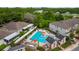 Aerial view of a neighborhood pool with lounge chairs and surrounding greenery at 10066 Corso Milano Dr, Tampa, FL 33625