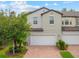 Charming townhouse with a two-car garage and brick paver driveway surrounded by lush landscaping at 10066 Corso Milano Dr, Tampa, FL 33625