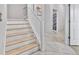 Staircase with wood treads, white risers, and a view of the upstairs bathroom at 10066 Corso Milano Dr, Tampa, FL 33625
