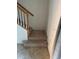 Carpeted staircase with wooden railing, leading to the upper level of the home at 20294 Lagente Cir, Venice, FL 34293