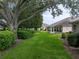 Backyard view showcasing a large tree and lush landscaping at 604 Masterpiece Dr # 604, Sun City Center, FL 33573