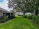 Landscaped backyard with mature trees and a grassy area at 604 Masterpiece Dr # 604, Sun City Center, FL 33573