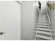 Modern gray and white staircase with a white door and gray walls at 240 Windward Psge # 605, Clearwater Beach, FL 33767