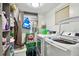 Convenient laundry room with washer, dryer, and storage shelving at 240 Windward Psge # 605, Clearwater Beach, FL 33767