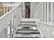 Stylish staircase with white railings and gray flooring at 240 Windward Psge # 605, Clearwater Beach, FL 33767