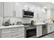 Bright kitchen with white cabinets, stainless steel appliances, and quartz countertops at 240 Windward Psge # 605, Clearwater Beach, FL 33767