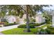 Tan two-car garage villa with lush landscaping at 2078 Sifield Greens Way # 05, Sun City Center, FL 33573