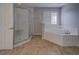 Bathroom featuring a shower, a soaking tub and a window with white shutter blinds at 19334 Autumn Woods Ave, Tampa, FL 33647