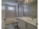 Bathroom with a bathtub, a toilet, and a vanity with white marble countertop at 19334 Autumn Woods Ave, Tampa, FL 33647